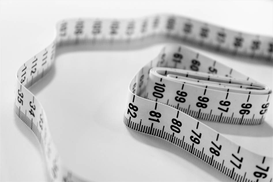 Yellow measuring tape coiled on wooden surface